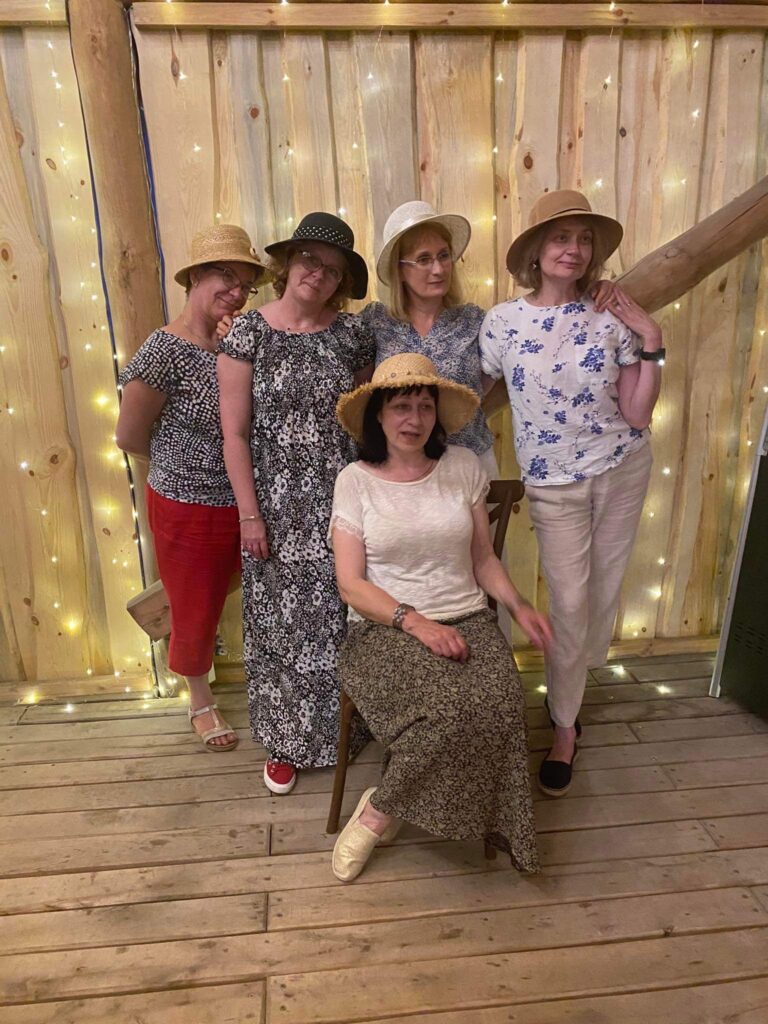 Fotografia przestawia pięć nauczycielek stojących razem w kapeluszach. 