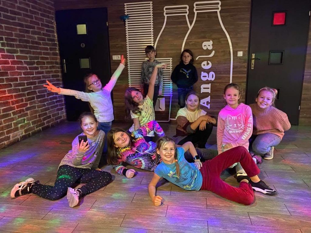 Zdjęcie przedstawia uczniów klasy III, którzy w oczekiwaniu na pizzę tańczą i bawią się na parkiecie.