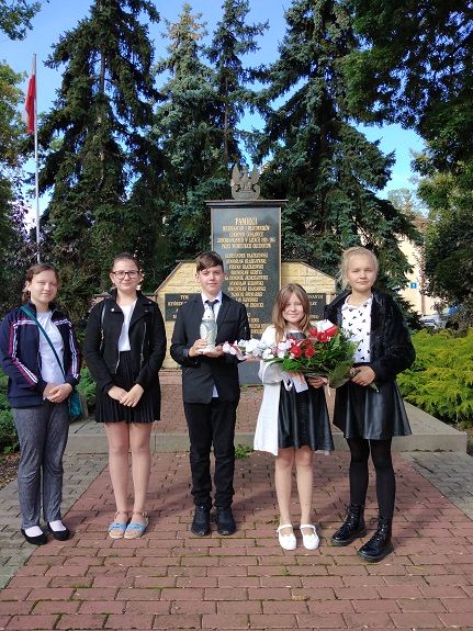 Uczniowie składają kwiaty pod pomnikiem pomordowanych podczas drugiej wojny światowej