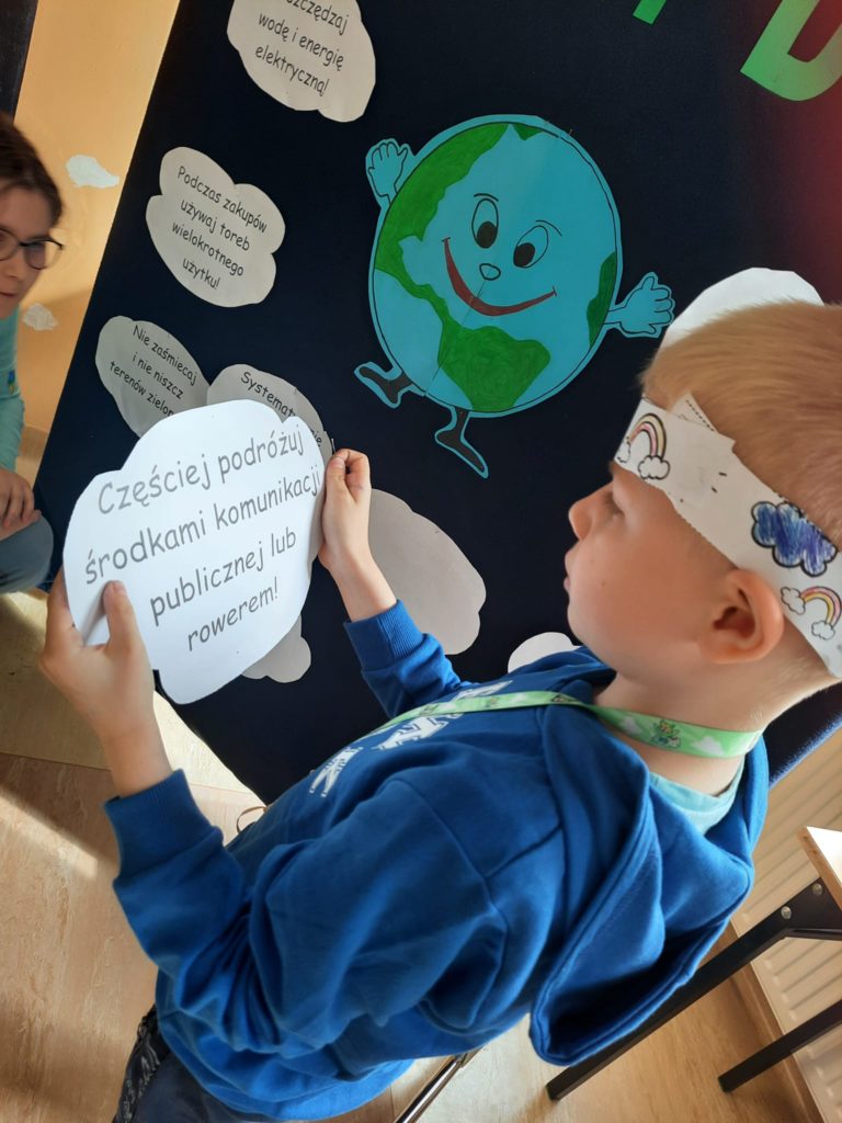 uczeń odczytuje hasło ekologiczne zapisane na kartce w kształcie chmurki 
